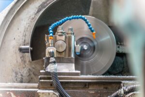 Pekerja mengoperasikan mesin di pabrik, menunjukkan Skill Teknis Teknik Permesinan yang Dicari Perusahaan di Jawa Timur
