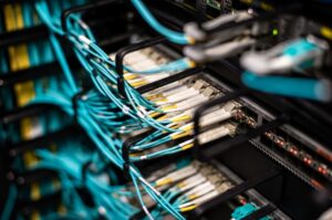 Gambar seorang siswa SMK Teknik Jaringan Komputer dan Telekomunikasi / Teknik Komputer dan Jaringan sedang belajar di depan server, menggambarkan prospek kerja sebagai network administrator.