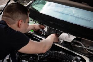 Seorang teknisi sedang memeriksa sistem baterai EV, menunjukkan Teknik Kendaraan Ringan di Era EV: Skill yang Harus Dikuasai.