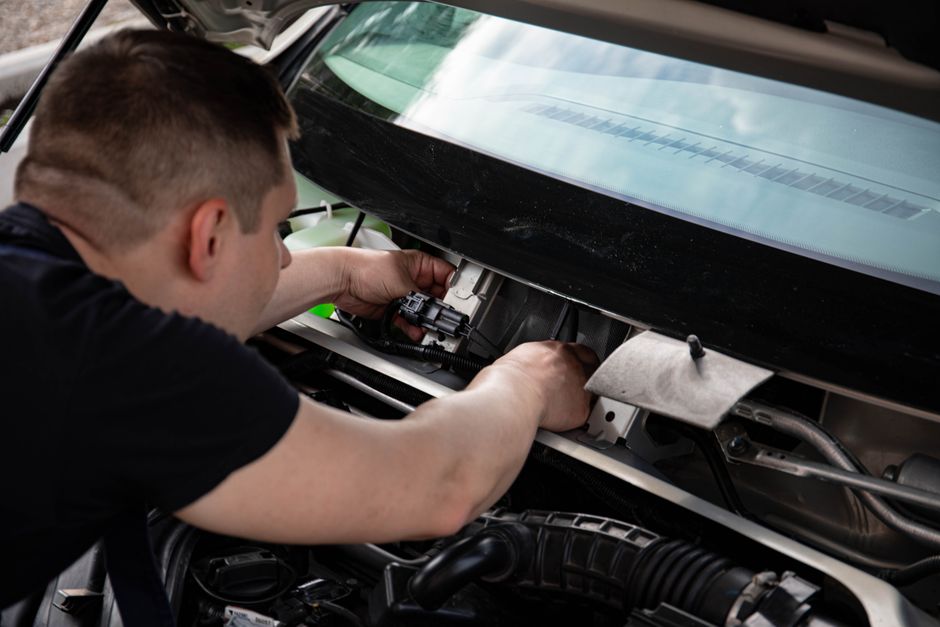 Seorang teknisi sedang memeriksa sistem baterai EV, menunjukkan Teknik Kendaraan Ringan di Era EV: Skill yang Harus Dikuasai.