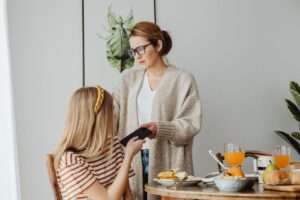Orang tua dan remaja berdiskusi, menciptakan momen positif dalam konteks Parenting Remaja.