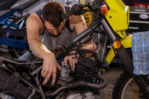 Tips Menjadi Teknisi Motor Profesional Lulusan SMK sedang bekerja di bengkel