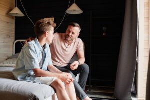 Seorang remaja perempuan yang sedang cemas didampingi orang tuanya, menggambarkan pentingnya Parenting Remaja.
